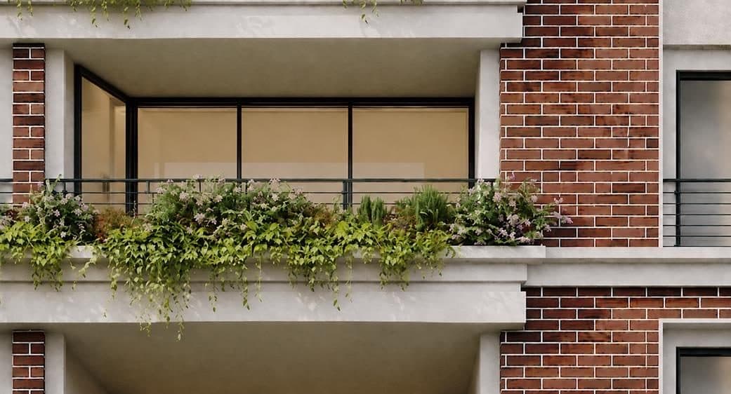 Detalle de un balcón con jardinera desbordada sobre el ladrillo aparente