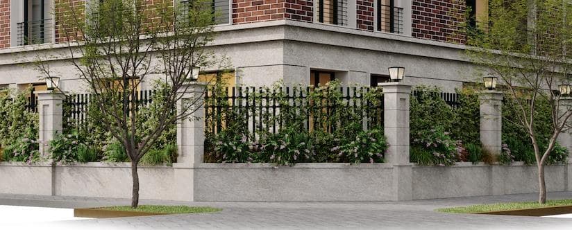 Stone perimeter wall and iron railing, with continuous planters and trees along the pavement